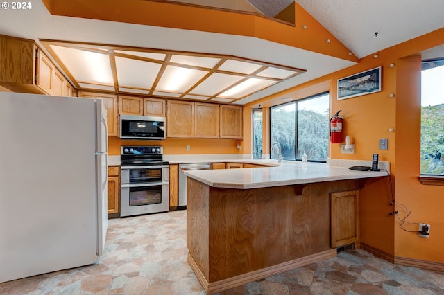 kitchen with stainless steel appliances, kitchen peninsula, and sink