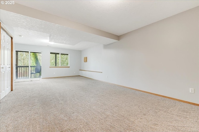 carpeted empty room featuring a textured ceiling