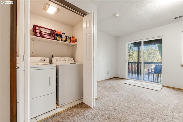 laundry area with carpet, separate washer and dryer, and a textured ceiling