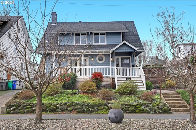 view of front of house with covered porch, a garage, and an outdoor structure