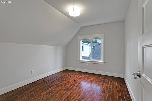 additional living space featuring dark hardwood / wood-style flooring and vaulted ceiling