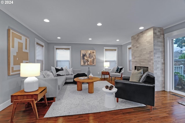 living room with a healthy amount of sunlight, dark hardwood / wood-style flooring, and crown molding