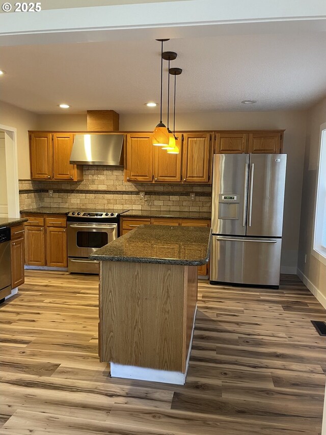 kitchen with sink, stainless steel dishwasher, dark hardwood / wood-style floors, kitchen peninsula, and pendant lighting