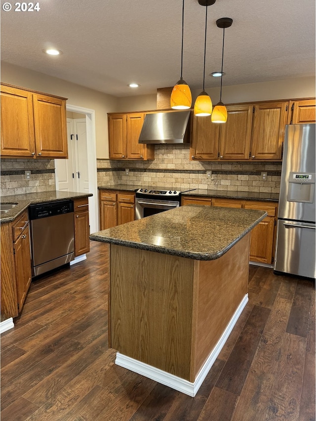 kitchen with a center island, wall chimney exhaust hood, decorative light fixtures, dark hardwood / wood-style flooring, and stainless steel appliances