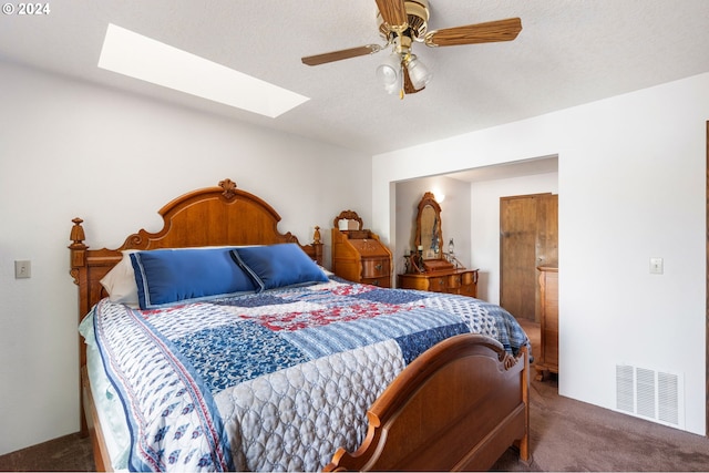 carpeted bedroom featuring ceiling fan and a skylight