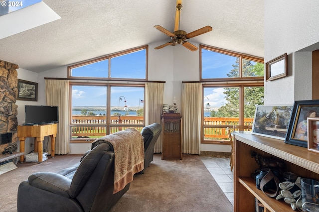 carpeted living room with ceiling fan, lofted ceiling, and a textured ceiling