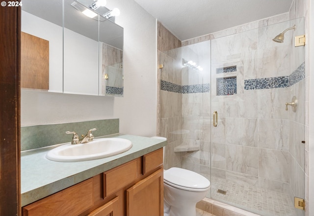 bathroom featuring toilet, a shower with door, and vanity