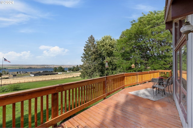 deck with a yard and a water view