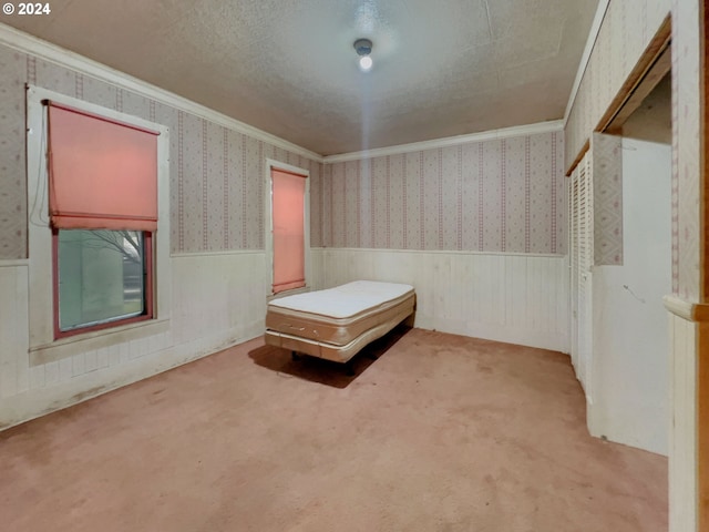 unfurnished bedroom featuring light carpet, crown molding, and a textured ceiling