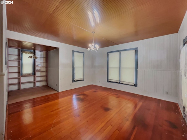 spare room featuring wooden ceiling, hardwood / wood-style floors, and a notable chandelier