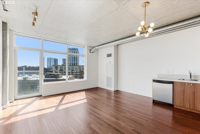 unfurnished living room with dark hardwood / wood-style flooring, a notable chandelier, and sink