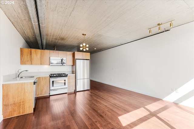 kitchen featuring stainless steel appliances, dark wood-type flooring, sink, decorative light fixtures, and a chandelier