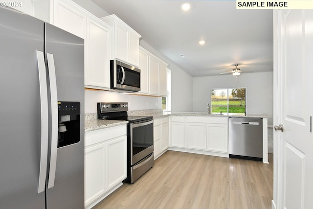 kitchen featuring ceiling fan, kitchen peninsula, stainless steel appliances, light wood-type flooring, and white cabinets