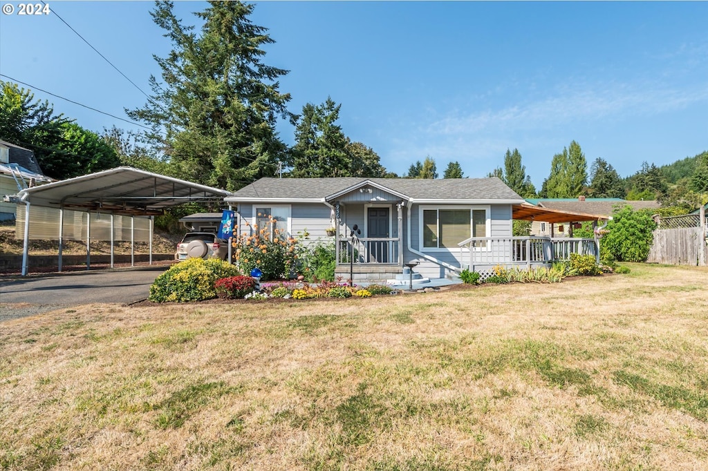 view of front of home featuring a front lawn, covered porch, and a carport