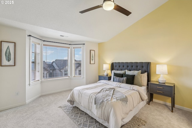 bedroom with ceiling fan, light colored carpet, and vaulted ceiling