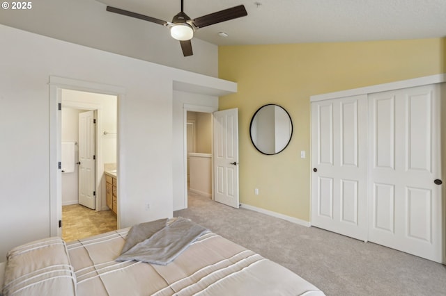 carpeted bedroom featuring a closet, vaulted ceiling, ceiling fan, and connected bathroom