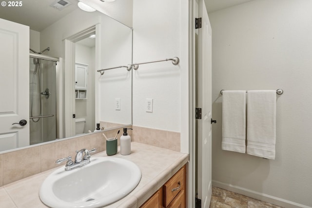 bathroom featuring a shower with door, toilet, and vanity