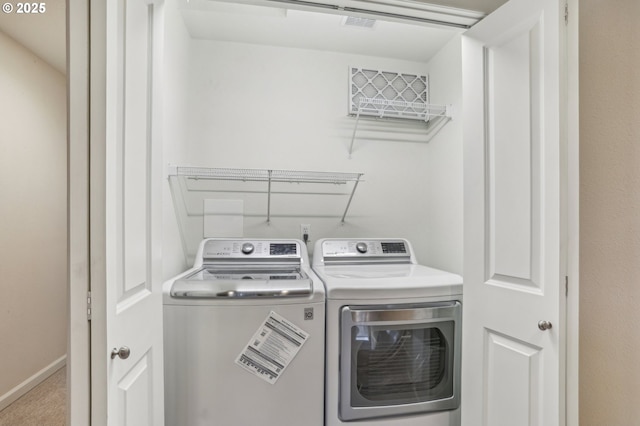 washroom with washing machine and dryer and light colored carpet