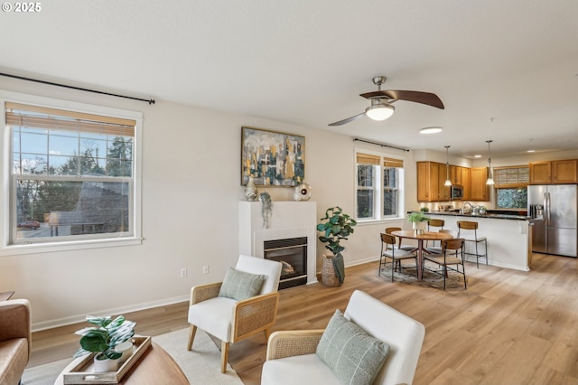 living room with light wood-type flooring and ceiling fan