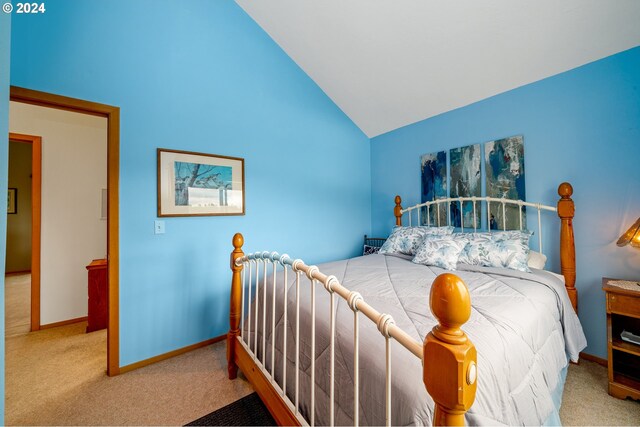 bedroom with high vaulted ceiling and carpet floors