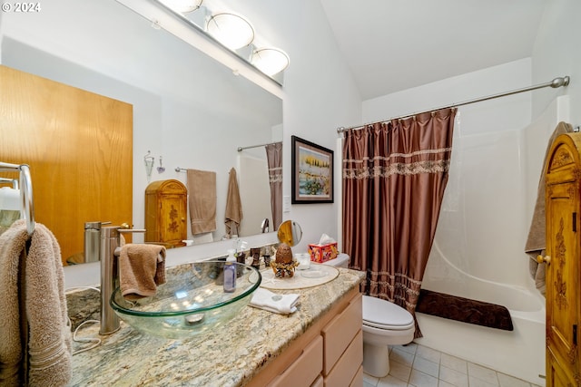 full bathroom featuring shower / bath combination with curtain, tile patterned floors, vanity, vaulted ceiling, and toilet