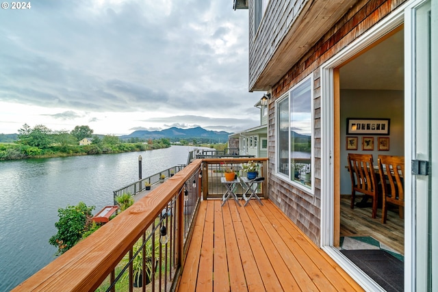 wooden terrace with a water and mountain view