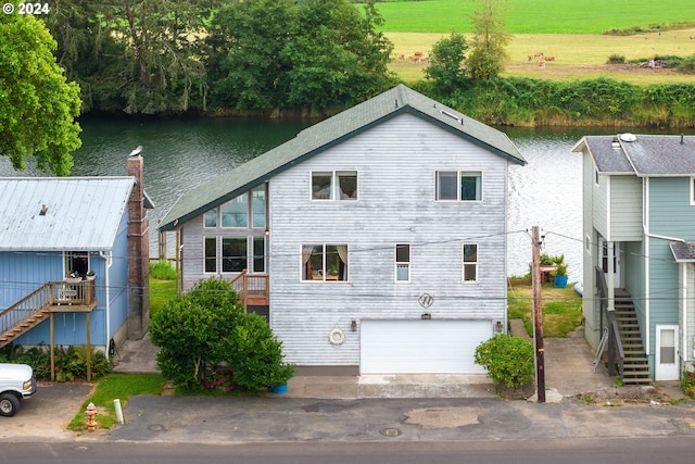 view of front of property featuring a garage and a water view