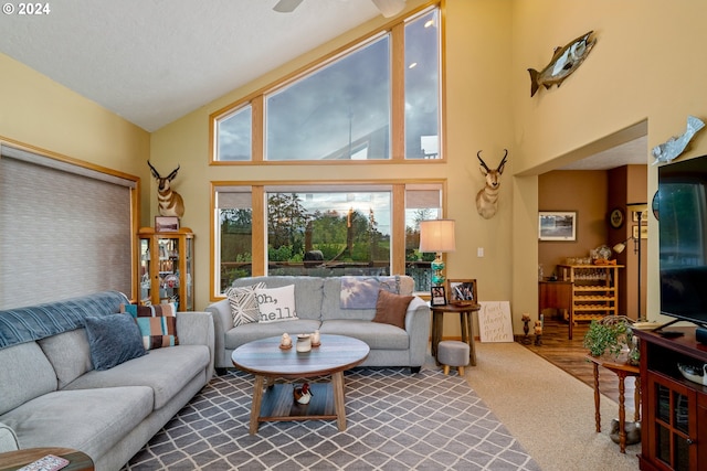 living room featuring hardwood / wood-style flooring, high vaulted ceiling, and ceiling fan