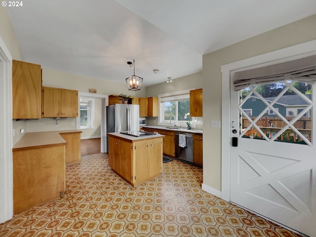 kitchen featuring pendant lighting, a center island, sink, a notable chandelier, and stainless steel appliances