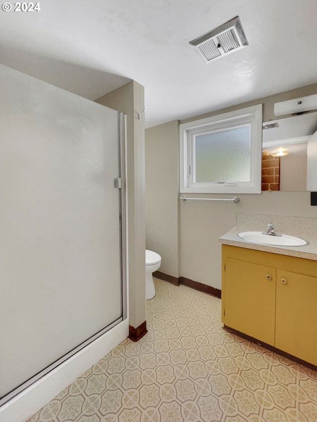 bathroom with vanity, toilet, and an enclosed shower