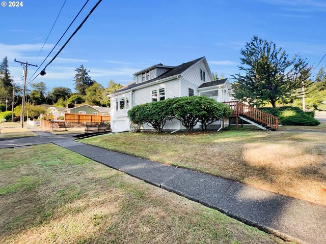 view of side of property featuring a deck and a yard