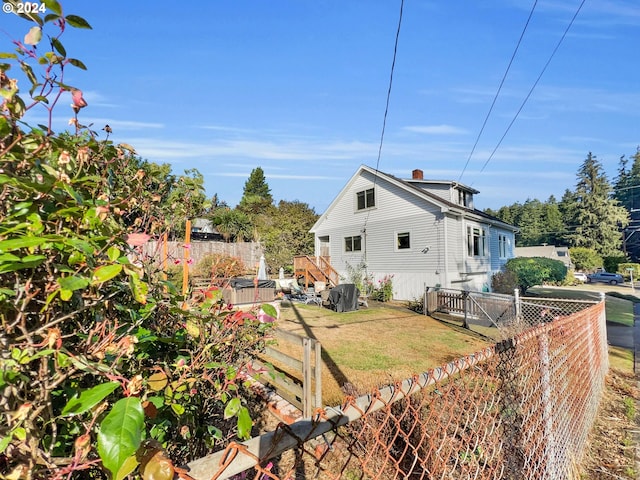 rear view of house featuring a wooden deck and a lawn