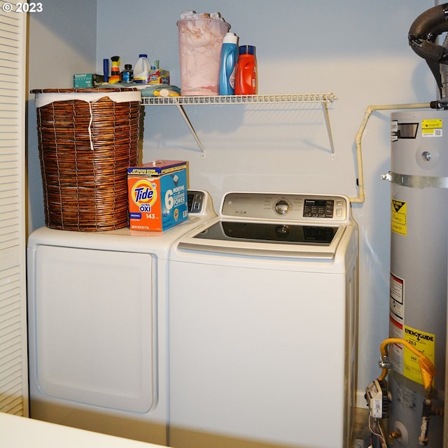 laundry room featuring strapped water heater and independent washer and dryer