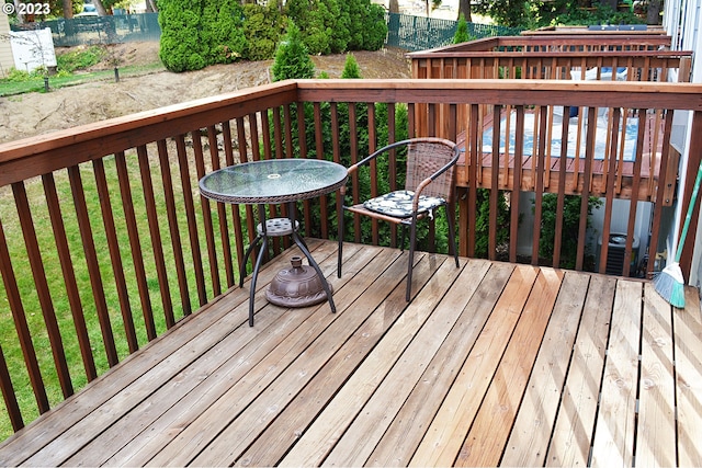 wooden terrace featuring a lawn