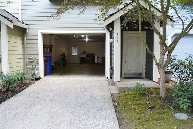 property entrance featuring concrete driveway and a garage