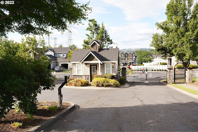 view of asphalt street with a gate, curbs, and a gated entry