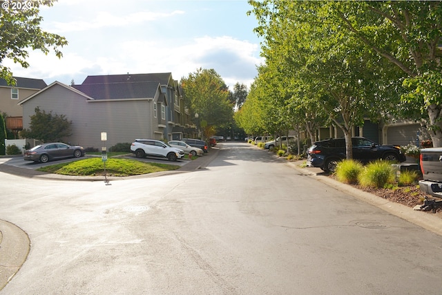 view of asphalt road with curbs and a residential view