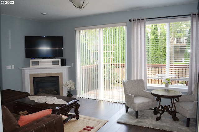 living room featuring plenty of natural light, wood finished floors, and a tile fireplace