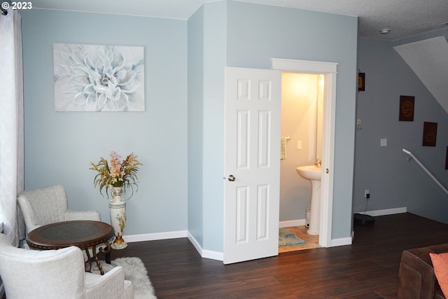 living area featuring dark wood-type flooring and baseboards