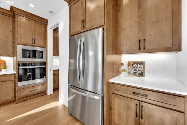 kitchen featuring appliances with stainless steel finishes and light hardwood / wood-style flooring