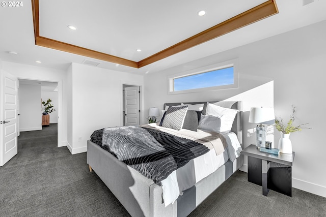 bedroom featuring dark carpet and a tray ceiling