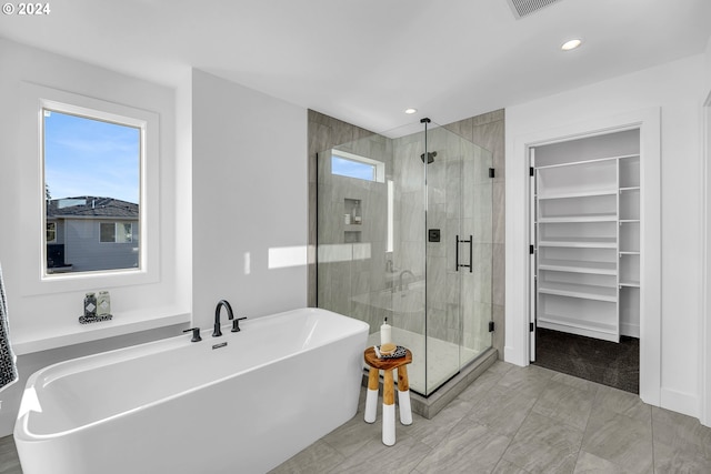 bathroom featuring separate shower and tub