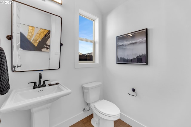 bathroom with toilet, wood-type flooring, and sink