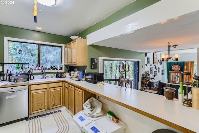 kitchen with stainless steel dishwasher, sink, hanging light fixtures, and an inviting chandelier