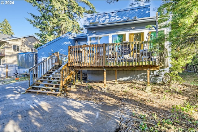 rear view of house featuring a wooden deck