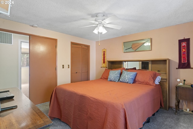 carpeted bedroom featuring ceiling fan, visible vents, and a textured ceiling