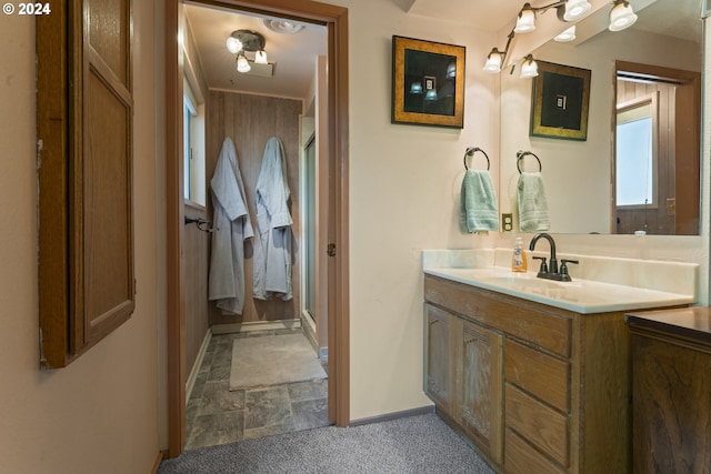 bathroom featuring baseboards, a stall shower, and vanity