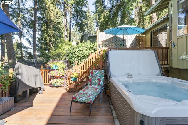 wooden terrace featuring area for grilling, fence, and a hot tub