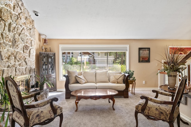 carpeted living area featuring baseboards, a fireplace, and vaulted ceiling