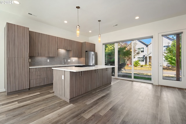 kitchen with hardwood / wood-style floors, stainless steel appliances, and a kitchen island